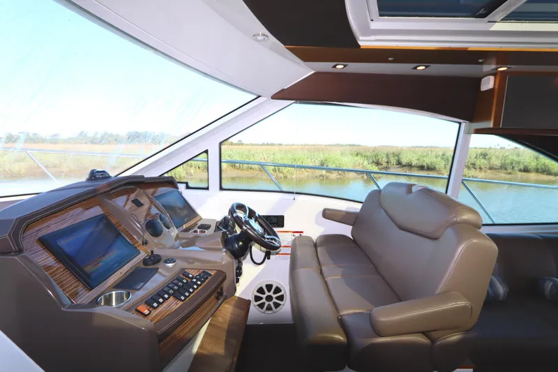 Slide: The Image of 2015 Cruisers Cantius yacht interior with modern helm and plush seating. - 47