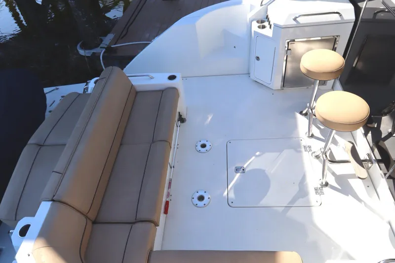 Slide: The Image of 2015 Cruisers Cantius boat deck with tan seating and stools. - 7