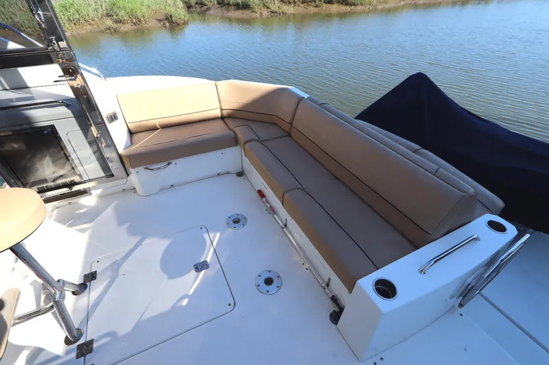 Slide: The Image of 2015 Cruisers Cantius boat with spacious outdoor seating by the water. - 8
