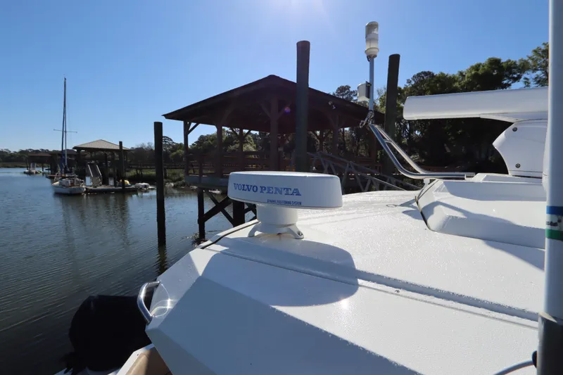 Slide: The Image of 2015 Cruisers Cantius boat with Volvo Penta equipment docked by a serene waterfront. - 28