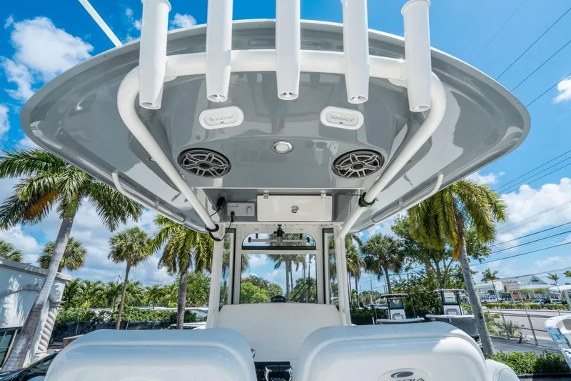 Slide: The Image of 2025 Cobia 285 CC boat with T-top and rod holders, set against a tropical backdrop. - 25