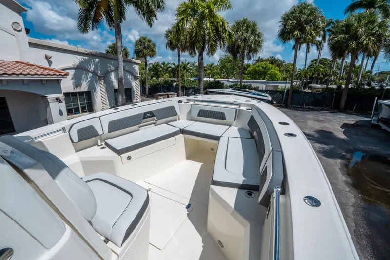 Slide: The Image of 2025 Cobia 285 CC boat with spacious seating, surrounded by palm trees and a sunny sky. - 28