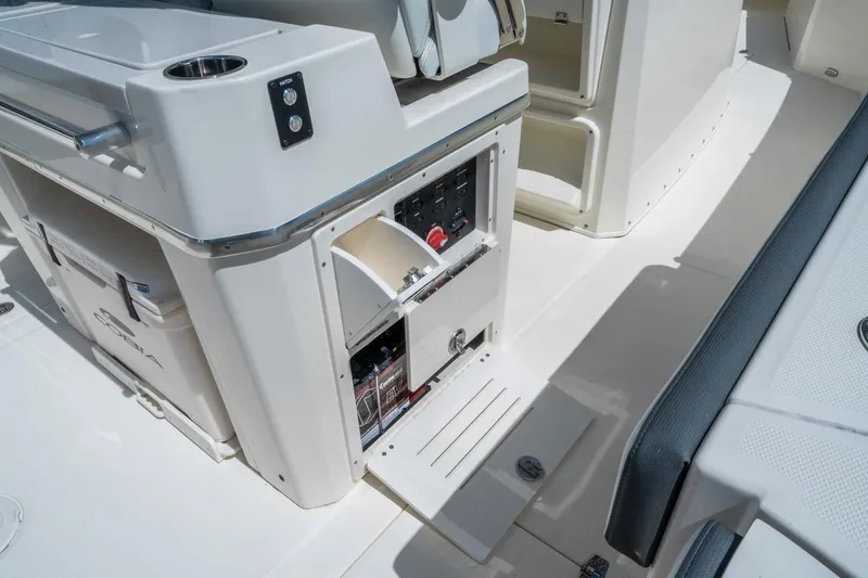 Slide: The Image of 2025 Cobia 285 CC boat interior with open storage compartment and control panel. - 18