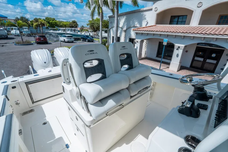 Slide: The Image of 2025 Cobia 285 CC boat interior with dual seats and steering wheel. - 23