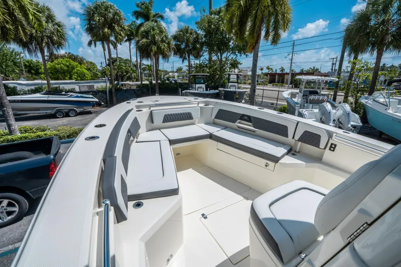 Slide: The Image of 2025 Cobia 285 CC boat interior with spacious seating under palm trees. - 27