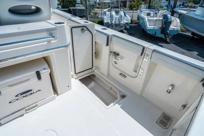 Slide: The Image of 2025 Cobia 285 CC boat interior with storage compartments and cooler. - 17