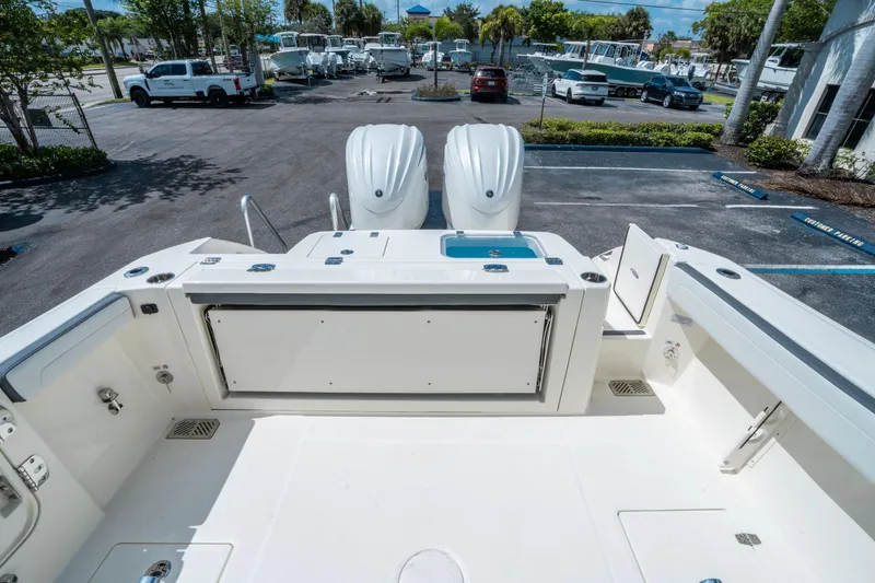 Slide: The Image of 2025 Cobia 285 CC boat deck with dual engines in a parking lot. - 10