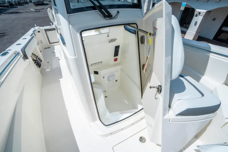 Slide: The Image of 2025 Cobia 285 CC boat interior with open storage compartment and seating. - 26