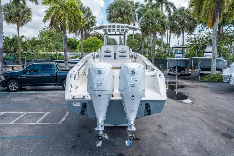 Slide: The Image of 2025 Cobia 285 CC boat with dual engines, parked outdoors among palm trees. - 3