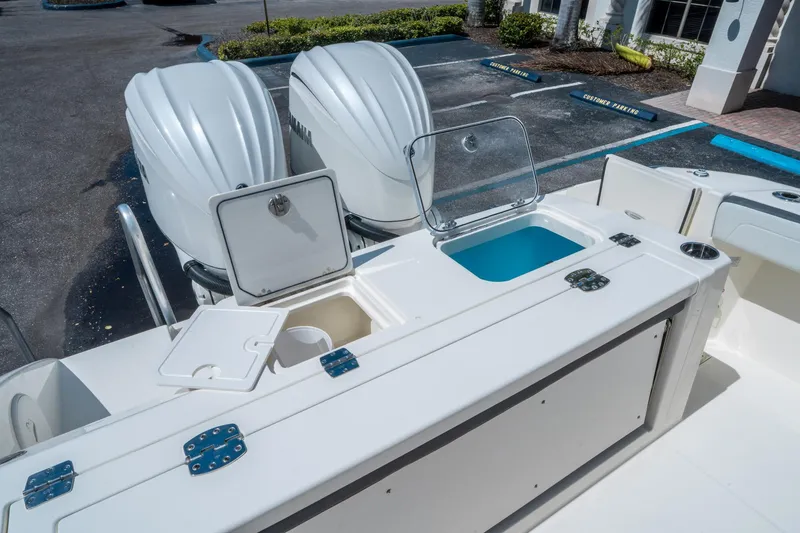Slide: The Image of 2025 Cobia 285 CC boat with dual outboard engines and open storage compartments. - 14