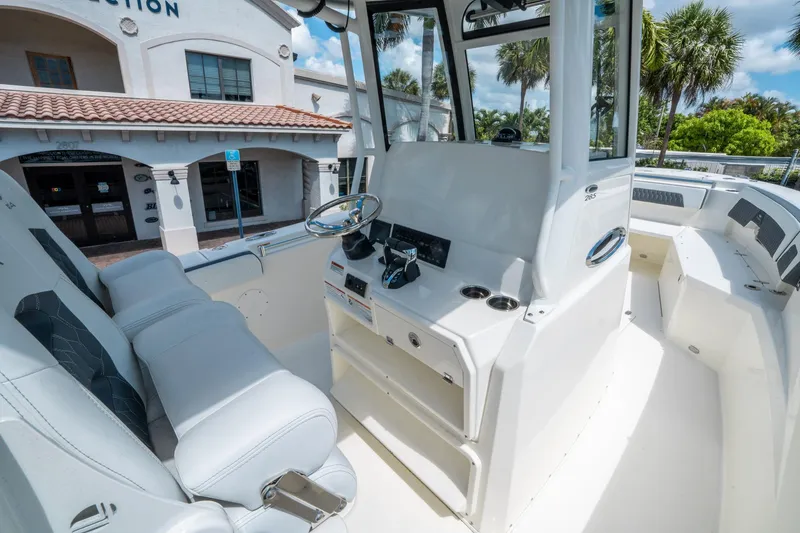 Slide: The Image of 2025 Cobia 285 CC boat interior with helm, white seating, and modern controls. - 21