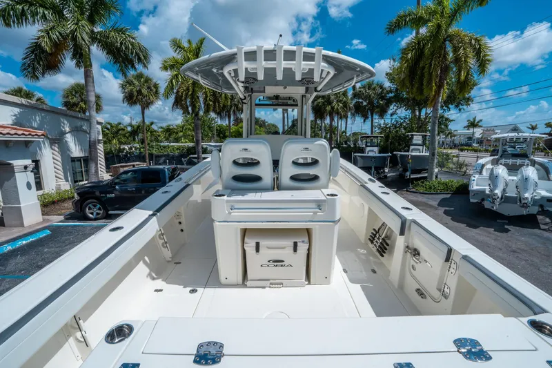 Slide: The Image of 2025 Cobia 285 CC boat interior with seating, palm trees, and blue sky background. - 9