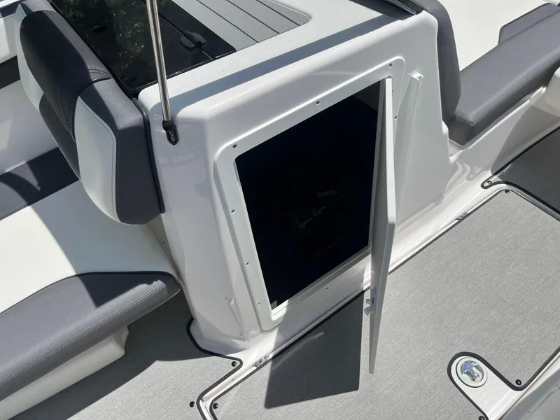 Slide: The Image of 2022 Yamaha AR210 boat storage compartment with open hatch, featuring sleek seating design. - 21