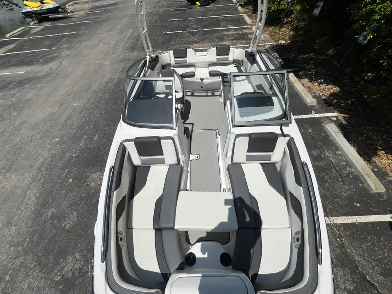 Slide: The Image of 2022 Yamaha Boats AR210, top view, spacious seating, parked on asphalt. - 23