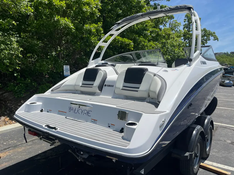 Slide: The Image of 2022 Yamaha AR210 boat on trailer, parked outdoors with lush greenery. - 3