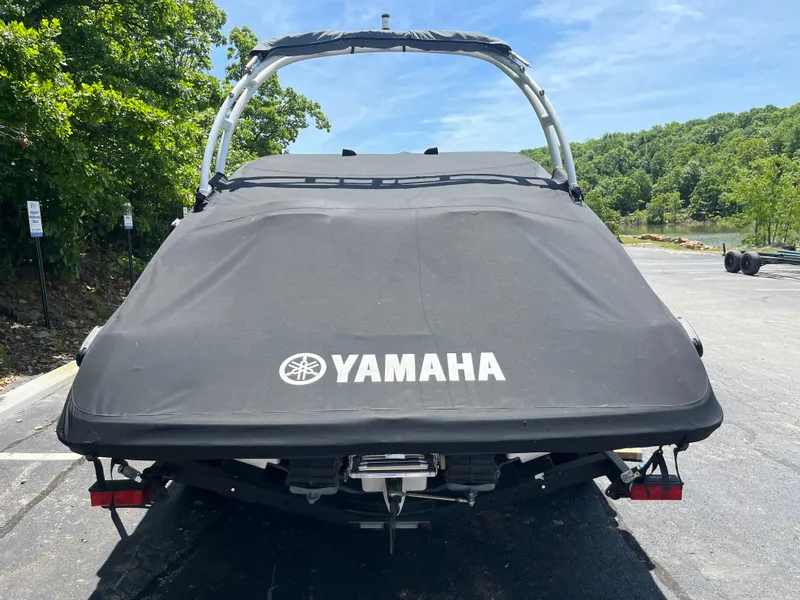 Slide: The Image of 2022 Yamaha AR210 boat with cover, parked outdoors on a sunny day. - 32