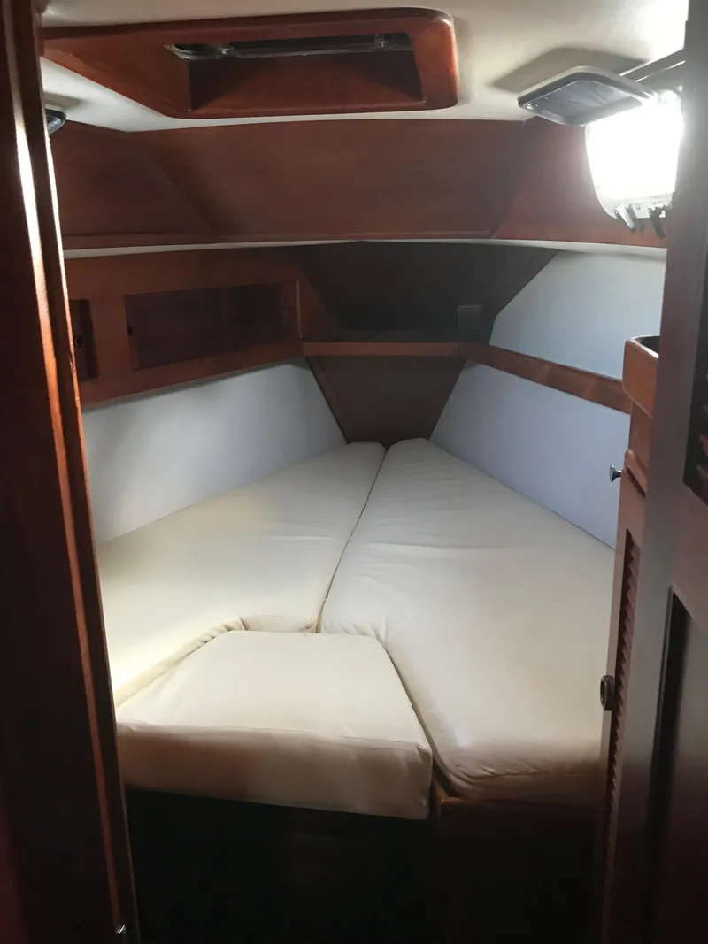 Slide: The Image of 1990 Endeavour 38 CC cabin interior with cozy V-berth and wooden accents. - 10