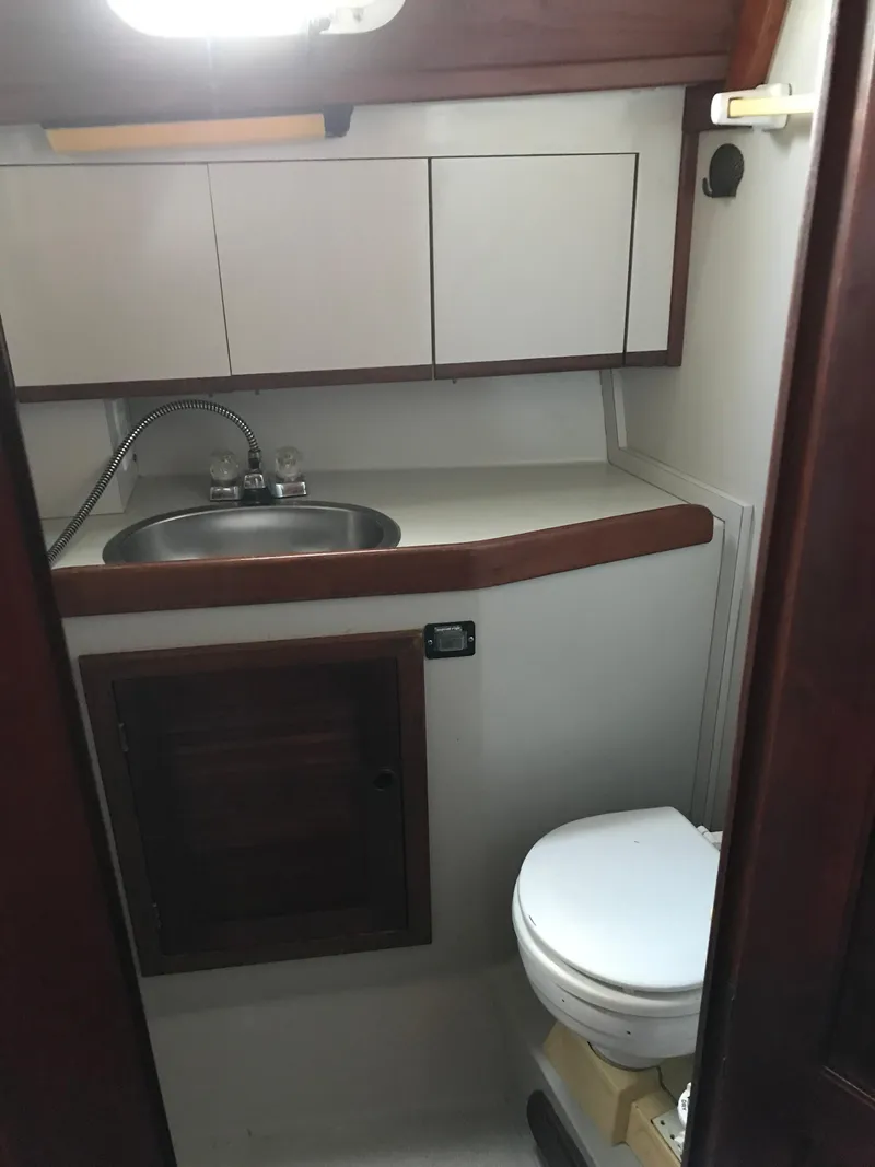 Slide: The Image of 1990 Endeavour 38 CC yacht bathroom with sink, cabinets, and toilet. - 9