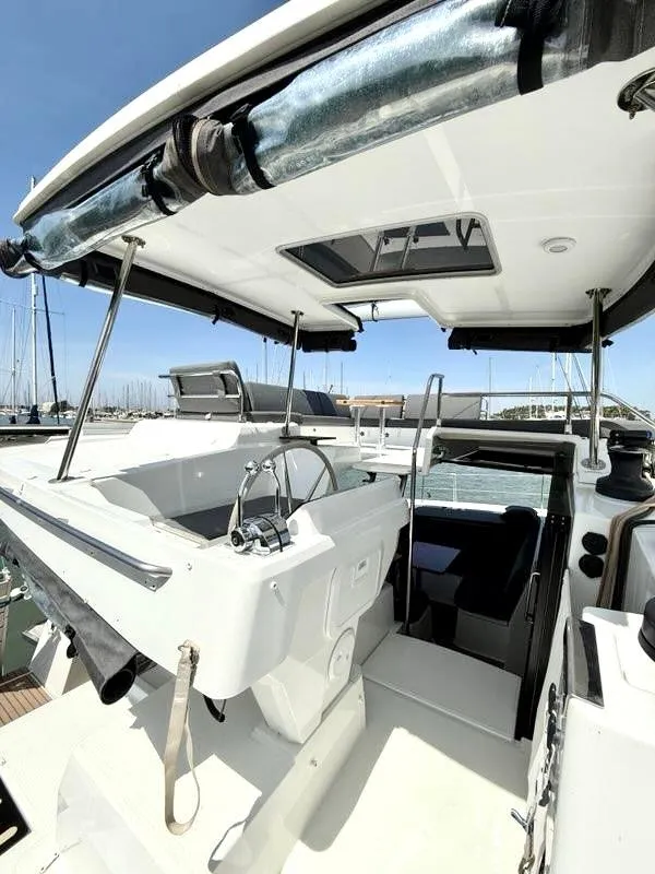 Slide: The Image of 2022 Fountaine Pajot Elba 45 catamaran cockpit with helm, marina background. - 15
