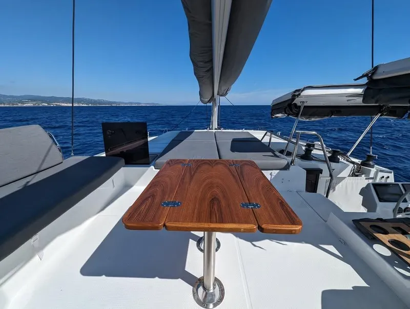 Slide: The Image of 2022 Fountaine Pajot Elba 45 yacht deck with wooden table and ocean view. - 17