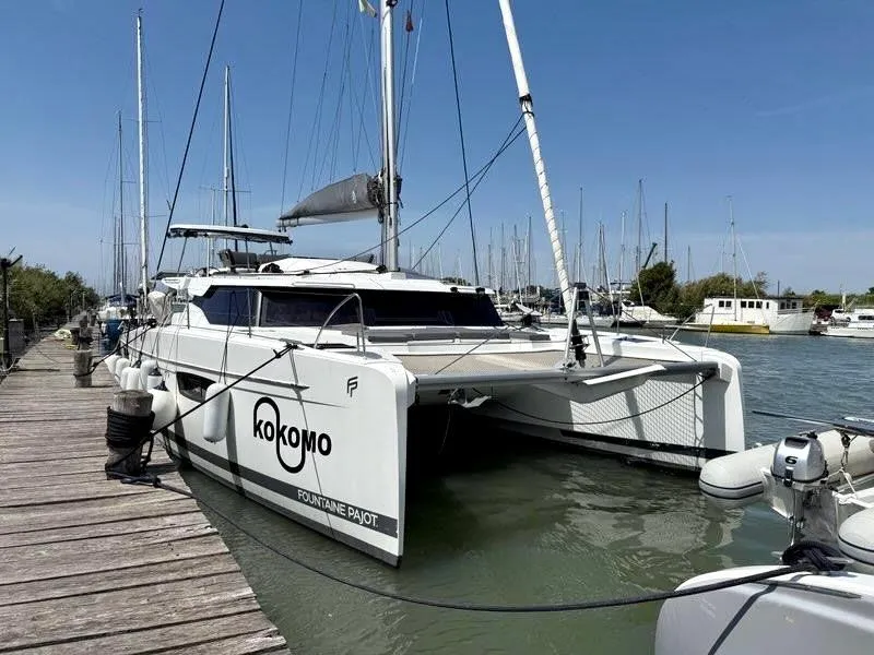 Slide: The Image of 2022 Fountaine Pajot Elba 45 catamaran docked at marina, clear sky background. - 3