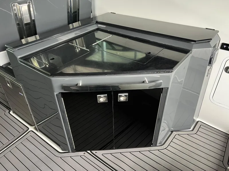 Slide: The Image of 2022 Cobalt A36BR boat interior with sleek, modern kitchenette and glossy black cabinetry. - 29