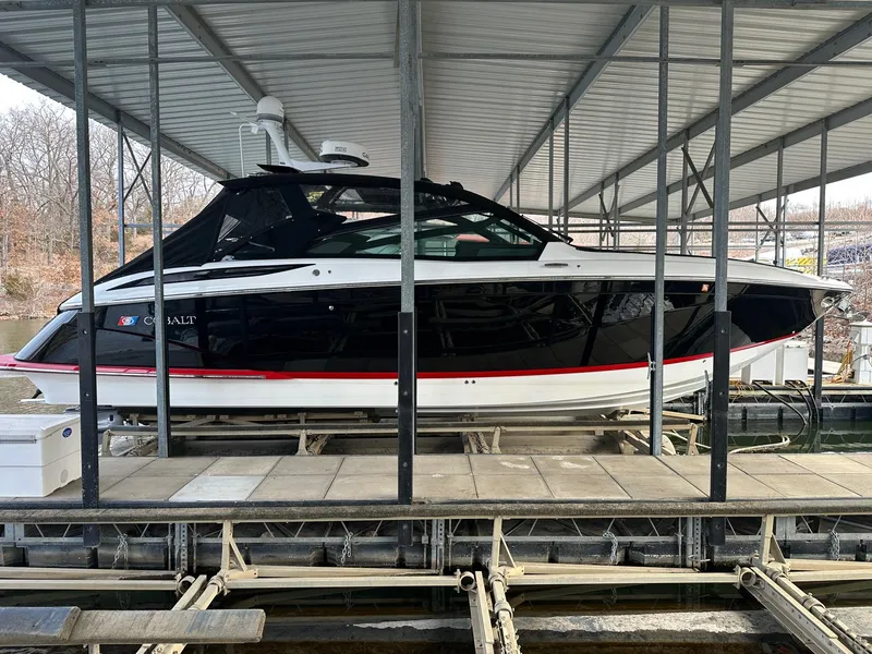 Slide: The Image of 2022 Cobalt A36BR boat docked under a covered marina. - 37