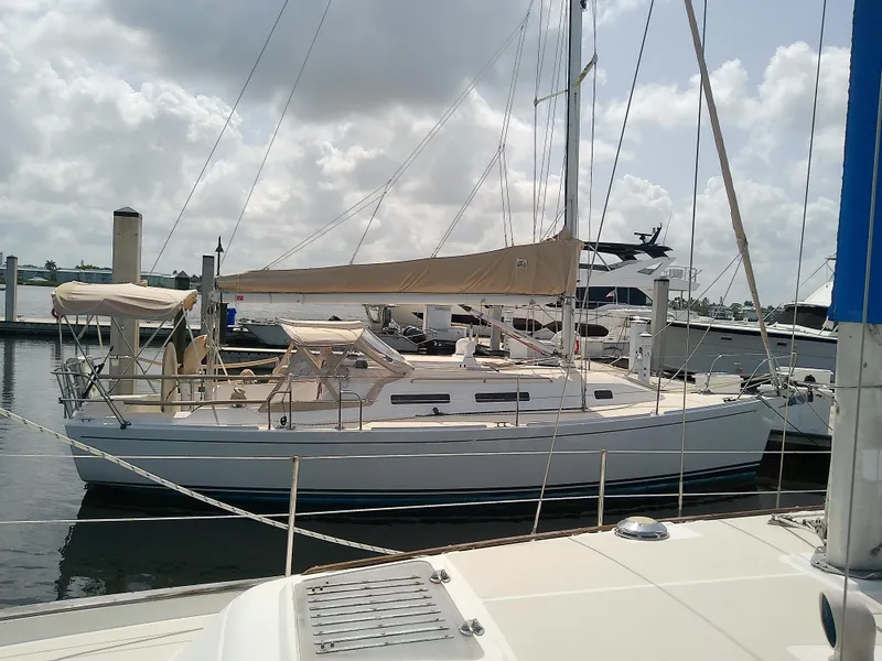 Slide: The Image of 2004 J Boats J/32 sailboat with beige sail cover, docked in a marina. - 11