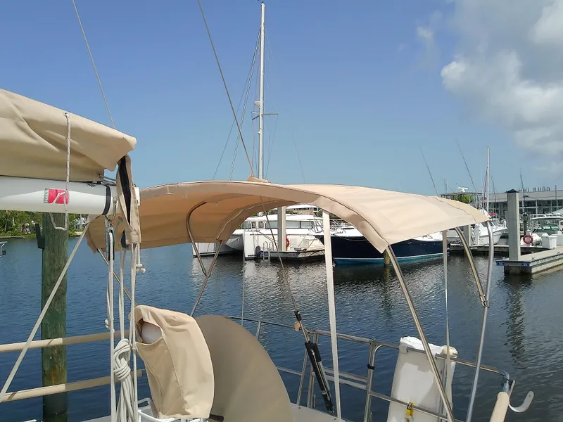 Slide: The Image of 2004 J Boats J/32 sailboat with beige canopy, docked in a marina. - 23