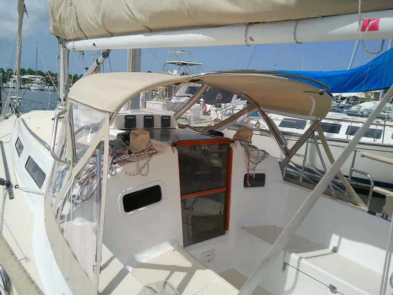Slide: The Image of 2004 J Boats J/32 sailboat cockpit with seating and equipment, docked on calm water. - 25