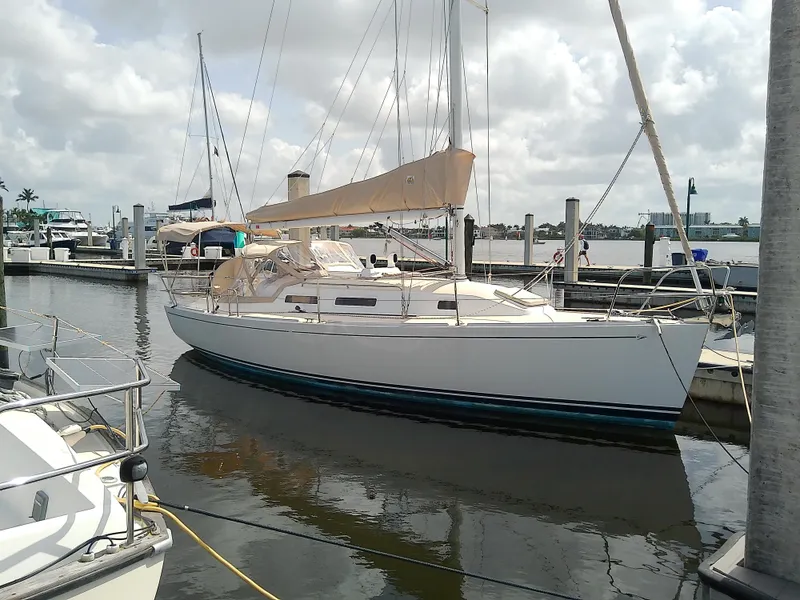 Slide: The Image of 2004 J Boats J/32 sailboat docked at a marina under cloudy skies. - 8