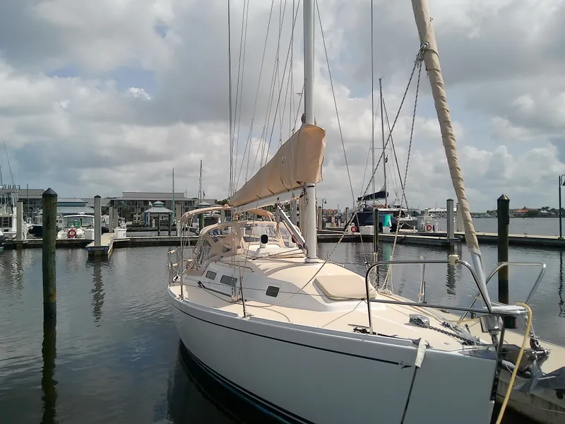 Slide: The Image of 2004 J Boats J/32 sailboat docked at marina under cloudy sky. - 9
