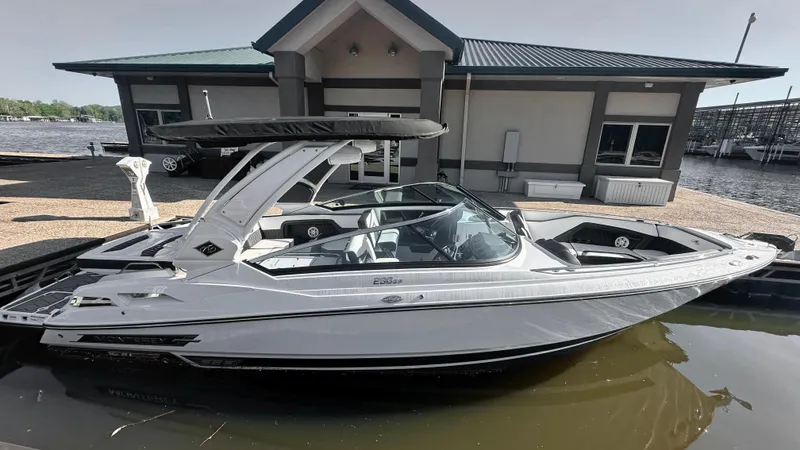 Slide: The Image of 2022 Monterey 298SS boat docked near a modern building by the water. - 1