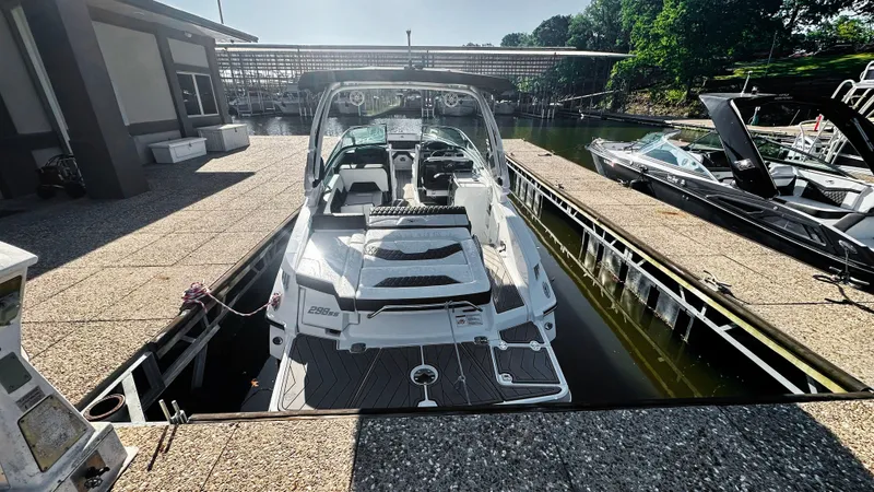 Slide: The Image of 2022 Monterey 298SS boat docked at marina, sunny day, surrounded by water and greenery. - 2