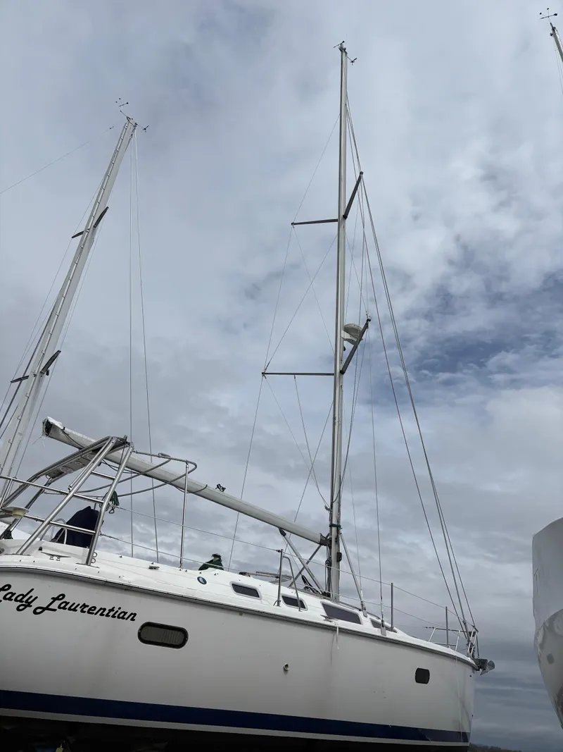 Slide: The Image of 2002 Hunter 356 sailboat with tall masts against a cloudy sky. - 2