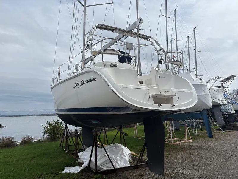 Slide: The Image of 2002 Hunter 356 sailboat on stands, docked near a calm waterfront. - 3