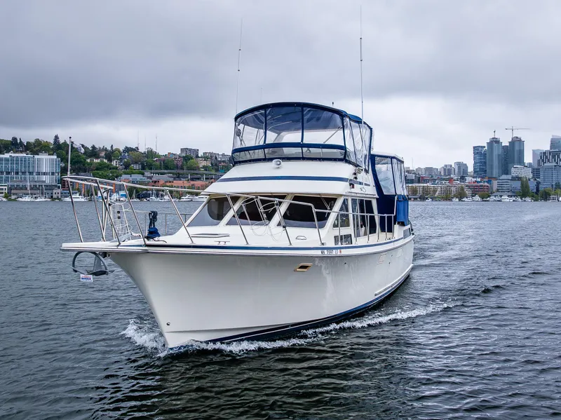 Slide: The Image of 1988 Tollycraft 44 CPMY cruising on a calm, overcast waterway near urban skyline. - 34