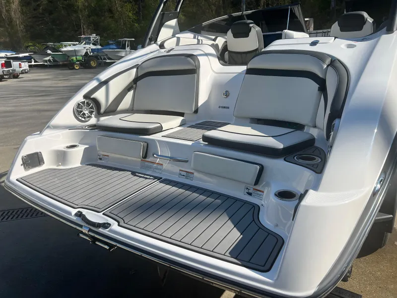Slide: The Image of 2019 Yamaha Boats 242 Limited S with sleek seating and modern design in a marina setting. - 3