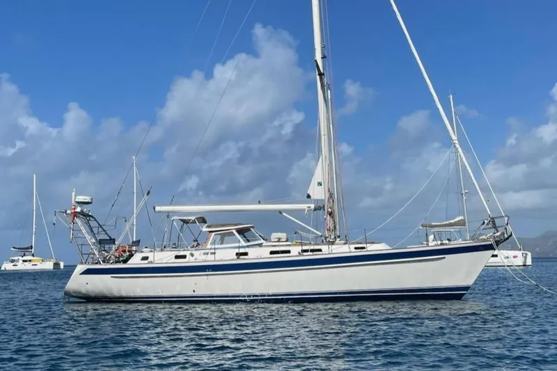 The Image of 2003 Hallberg-Rassy 46 sailboat anchored on calm sea under blue sky. - 0