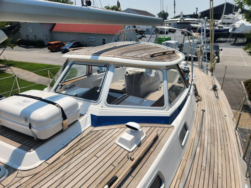 Slide: The Image of 2003 Hallberg-Rassy 46 sailboat with wooden deck and cabin, docked at a marina. - 15