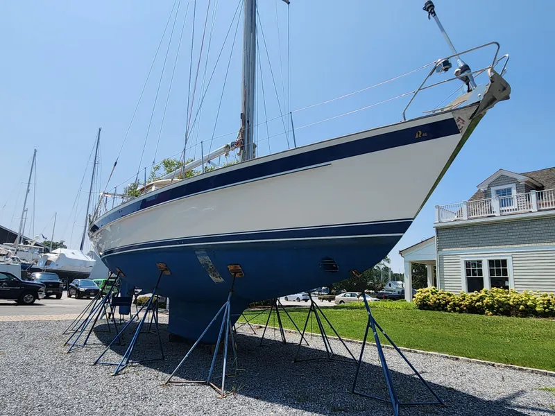 Slide: The Image of 2003 Hallberg-Rassy 46 sailboat on stands, displayed outdoors on a sunny day. - 2