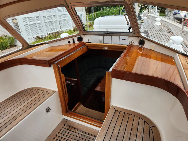 Slide: The Image of Cockpit of 2003 Hallberg-Rassy 46 sailboat with wooden seating and cabin entrance. - 26