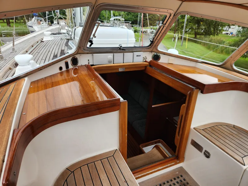 Slide: The Image of 2003 Hallberg-Rassy 46 yacht cockpit with wooden finish and open cabin entrance. - 27