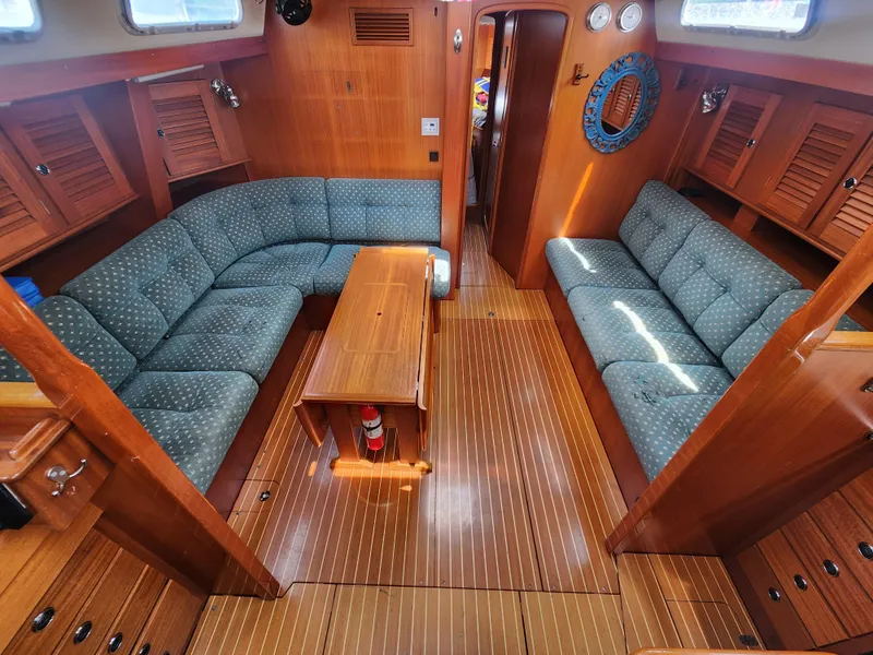 Slide: The Image of Interior of 2003 Hallberg-Rassy 46 yacht with wooden finish and blue upholstered seating. - 28