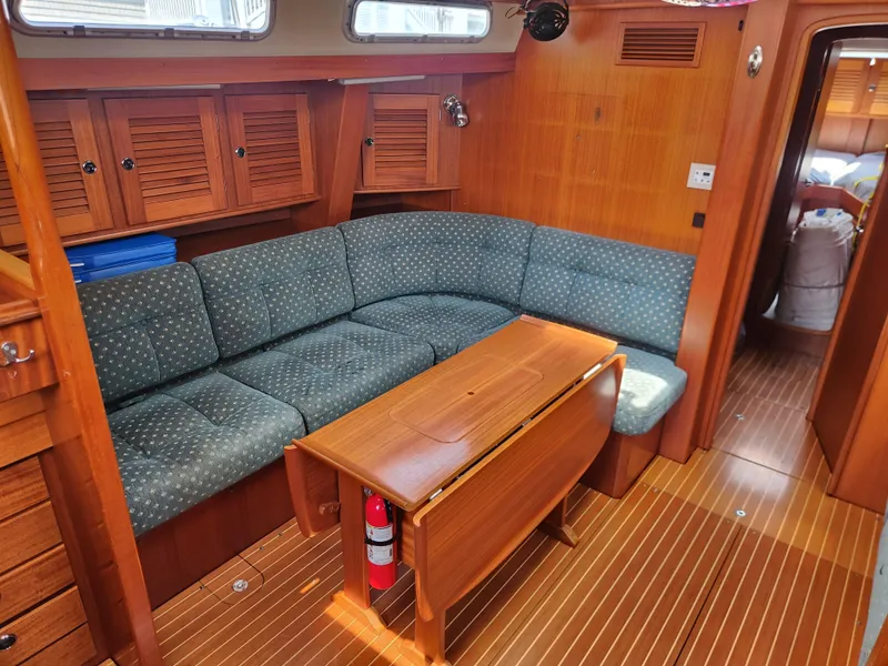 Slide: The Image of Interior of 2003 Hallberg-Rassy 46 yacht with wooden furnishings and blue cushioned seating. - 29