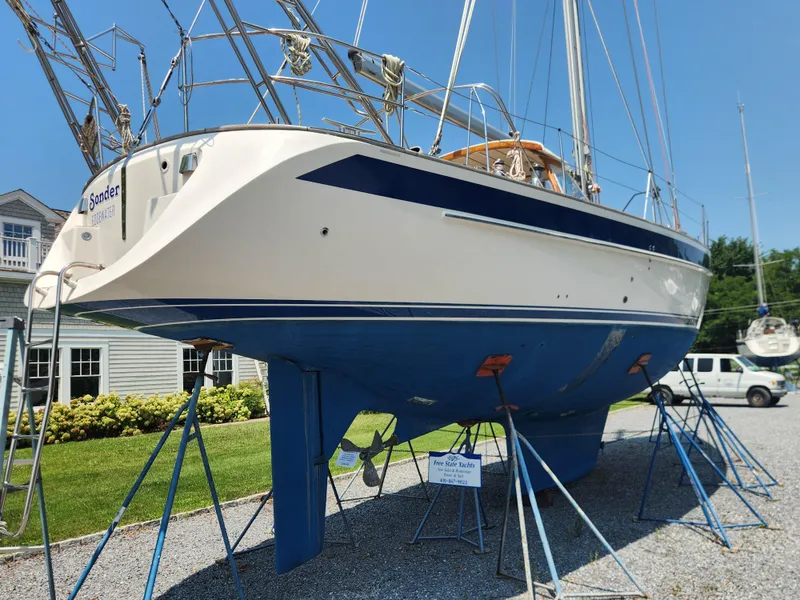Slide: The Image of 2003 Hallberg-Rassy 46 sailboat on stands, blue hull, sunny day, marina background. - 4