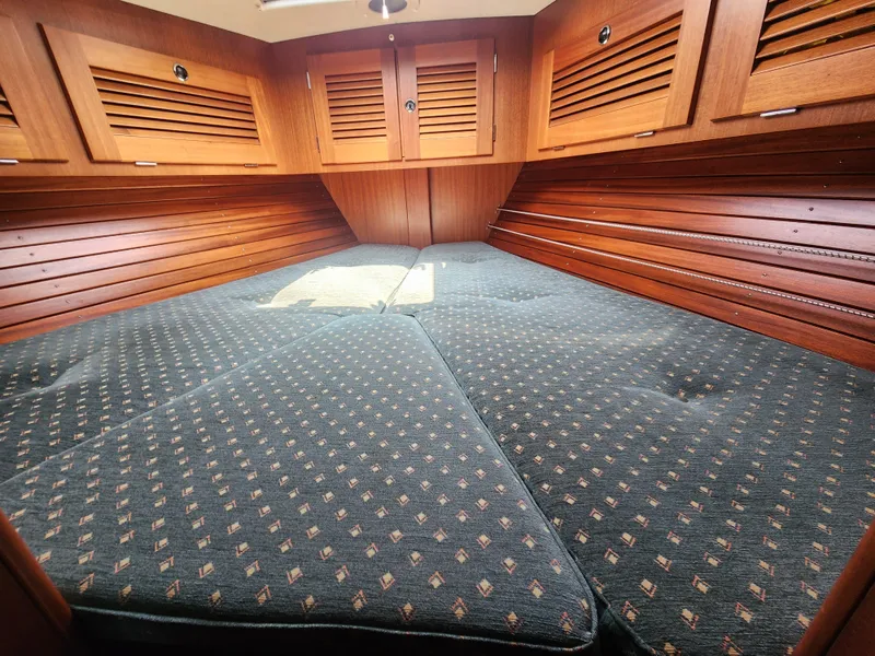 Slide: The Image of Interior cabin of 2003 Hallberg-Rassy 46 yacht with wooden paneling and patterned bedding. - 44