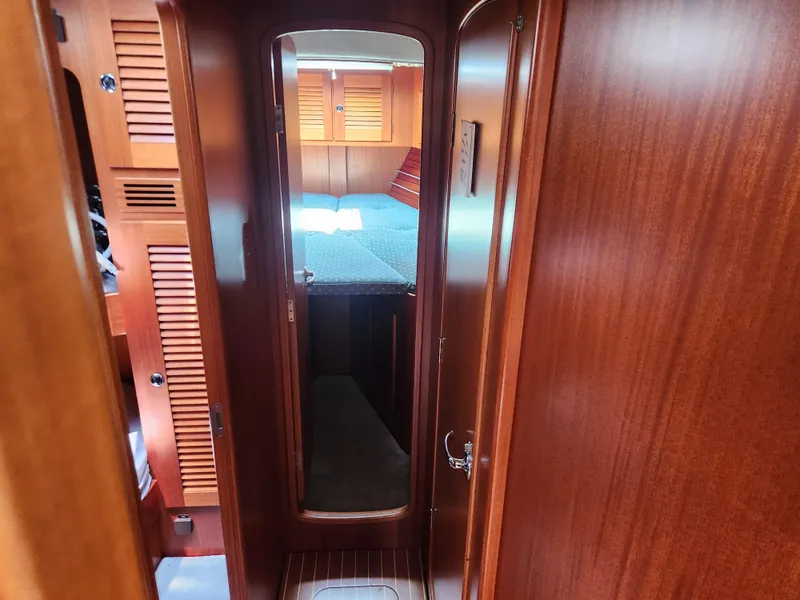 Slide: The Image of Interior of 2003 Hallberg-Rassy 46 yacht, featuring wooden cabinetry and cozy sleeping quarters. - 45