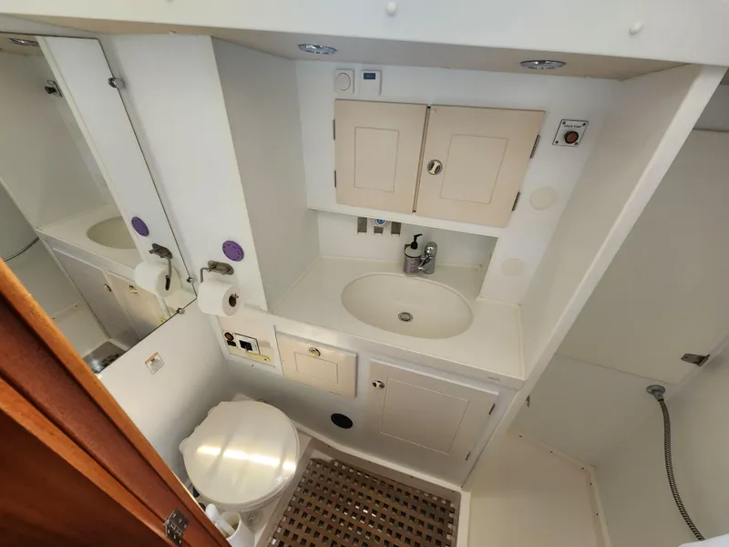 Slide: The Image of Bathroom interior of 2003 Hallberg-Rassy 46 yacht, featuring sink, toilet, and storage cabinets. - 48