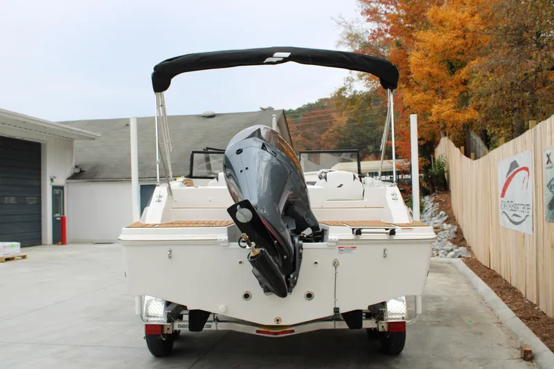 Slide: The Image of 2024 Starcraft SVX 210 OB DC boat, rear view, parked outdoors in autumn setting. - 3